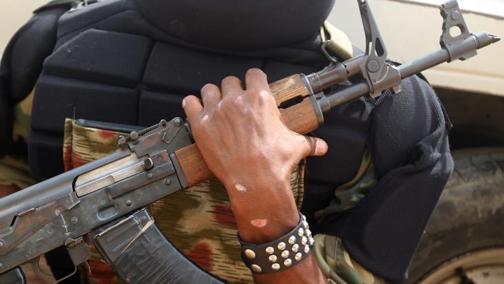 A person holding a Kalashnikov (photo: Ahmad-Al-Ruby/AFP/Getty Images)
