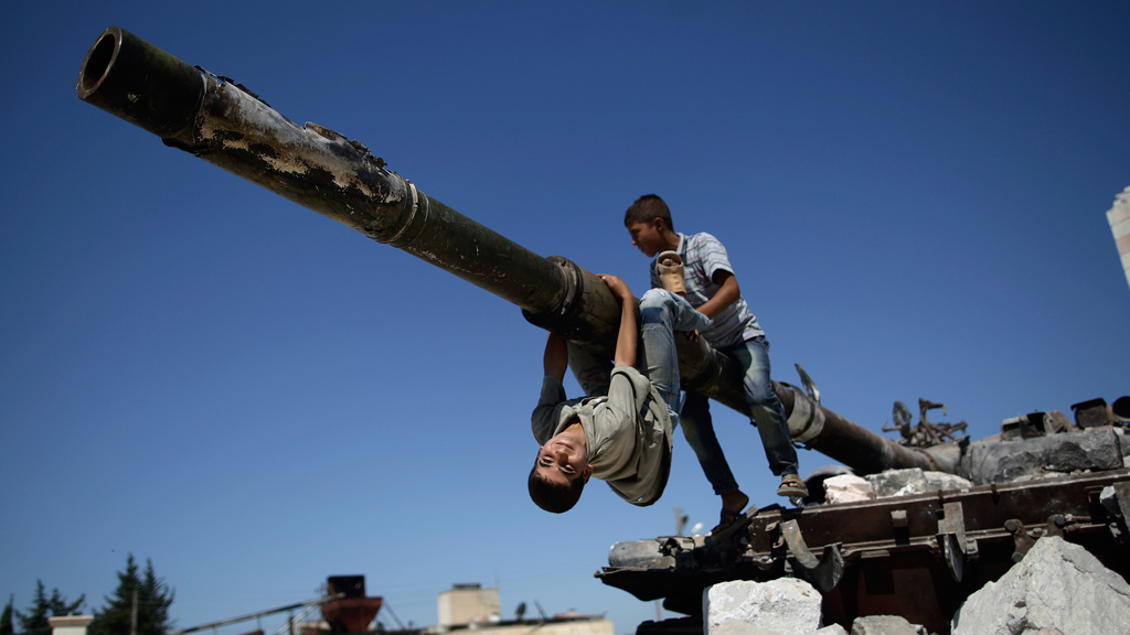 Kinder spielen auf einem zerstörten Panzer im syrischen Azaz; Foto: AP