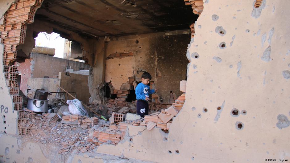 Ein kurdisches Kind in einem zerstörten Wohnhaus; Foto: DW