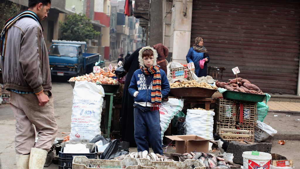 Boy stands in front of a stall near one of Cairo's markets (photo: Getty Images/J. Mitchell)