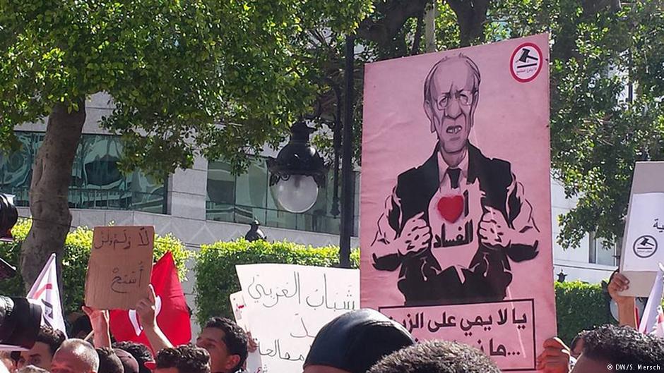 Plakat mit dem Bild Beji Said Essebsis und dem Schriftzug "Ich liebe Korruption" während der Manich Msameh Demonstration im Zentrum von Tunis am 13.5.2017; Foto: DW/Sarah Mersch