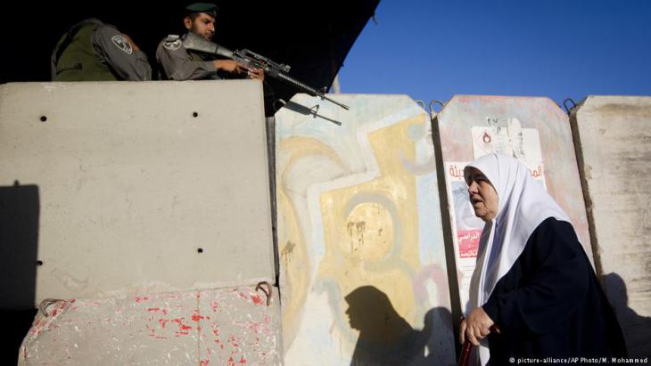 امرأة فلسطينية تمر في شهر رمضان في نقطة تفتيش قالنديا للصلاة في المسجد الأقصى.
