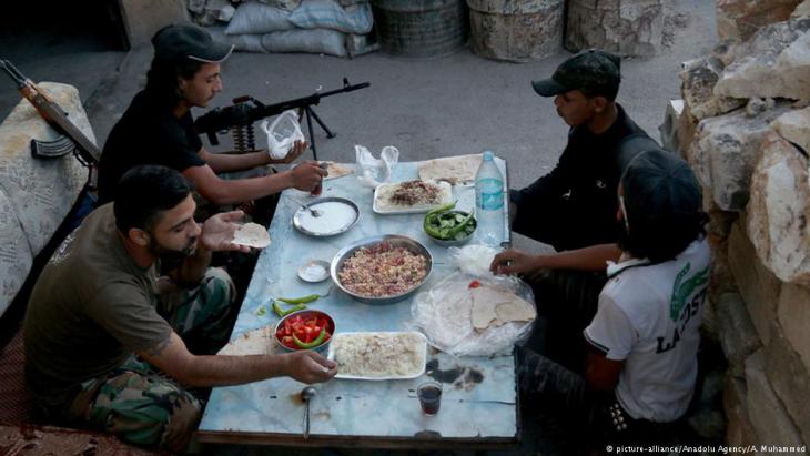 مقاتلون تابعون للمعارضة السورية أثناء تناول وجبة الإفطار في رمضان.
