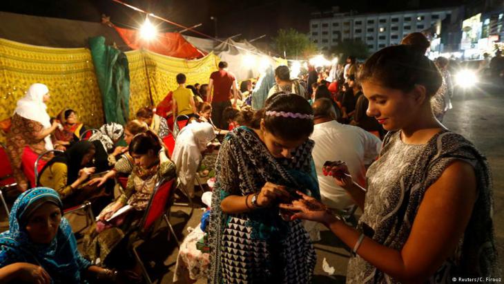 فتيات في باكستان ينقشن أيديهن بالحناء استعداداً لعيد الفطر.
