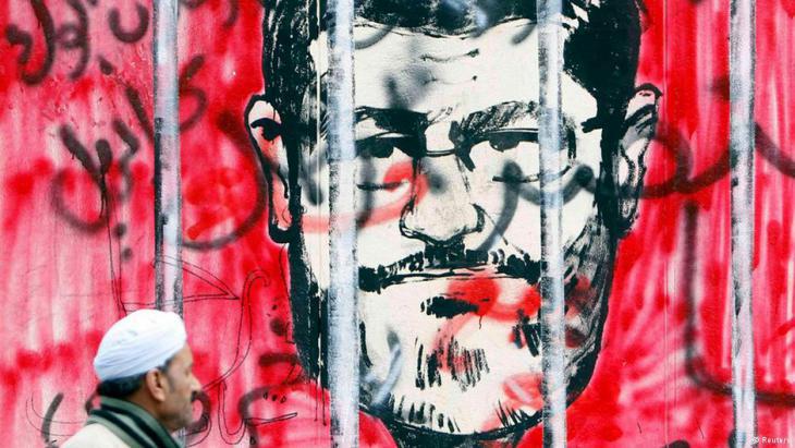 جدارية عليها رسم يُظهِر رئيس مصر الأسبق محمد مرسي خلف القضبان. Foto: Reuters