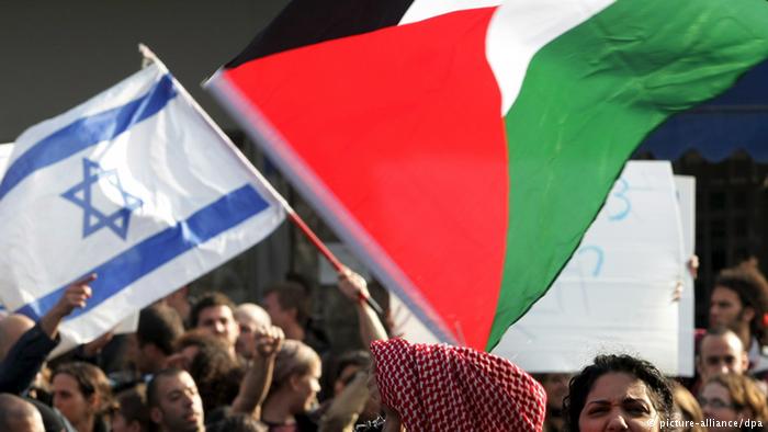 نشطاء سلام يحملون أعلام فلسطين وإسرائيل. Foto: dpa