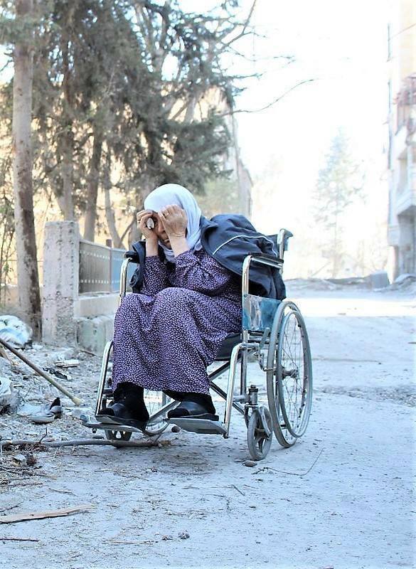 امرأة سورية على كرسي متحرك في مناطق قصف النظام السوري. الصورة عن طريق منصور حسنو