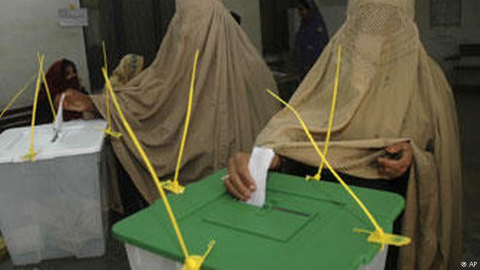 Women wearing burkas cast votes in Pakistani parliamentary elections (photo: AP)