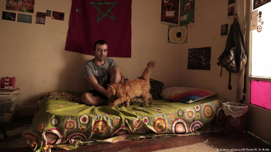 Yassin Mohammed sits with a cat in an apartment he shares, in Cairo, Egypt (photo: picture-alliance/AP Photo/N. El-Mofty)