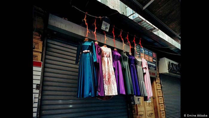 Colourful dresses suspended in front of a closed shop front (photo; Emine Akbaba)