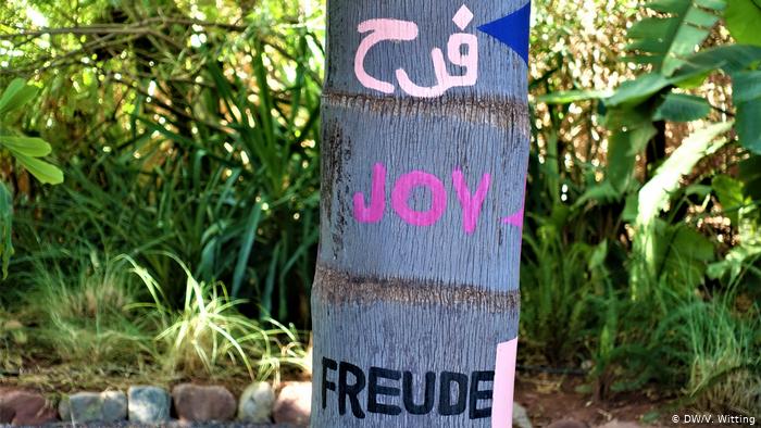 Morocco ANIMA Garden - close-up of a tree trunk with the word "Joy" painted in different languages (photo: DW/V. Witting)