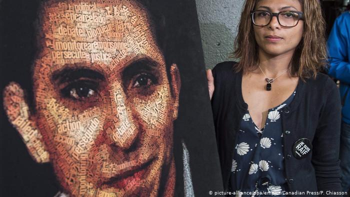 Ensaf Haidar, wife of Saudi blogger Raof Badawi, stands next to his image in Canada (photo: picture-alliance/dpa/empics/Canadian Press/P. Chiasson)