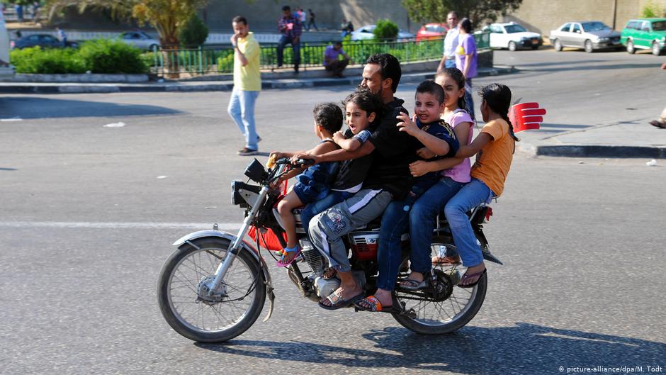 A father driving his five children on a motorbike to Tahrir Square in Cairo (photo: dpa/picture-alliance)