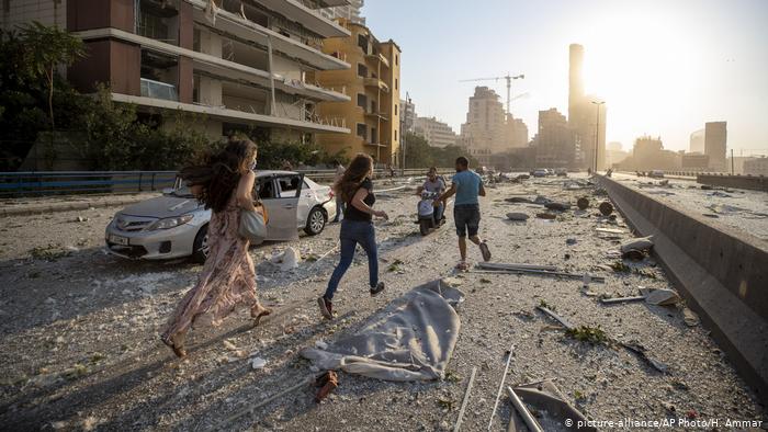 People in Beirut run through rubble in the explosion aftermath (photo: picture-alliance/AP Photo/H. Ammar)