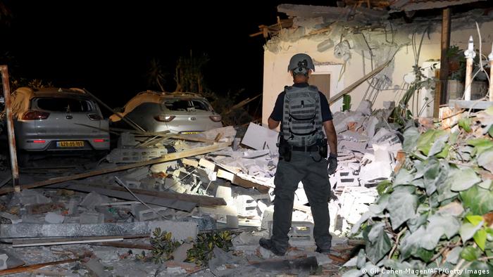 An Israeli soldier stands in the rubble of a building