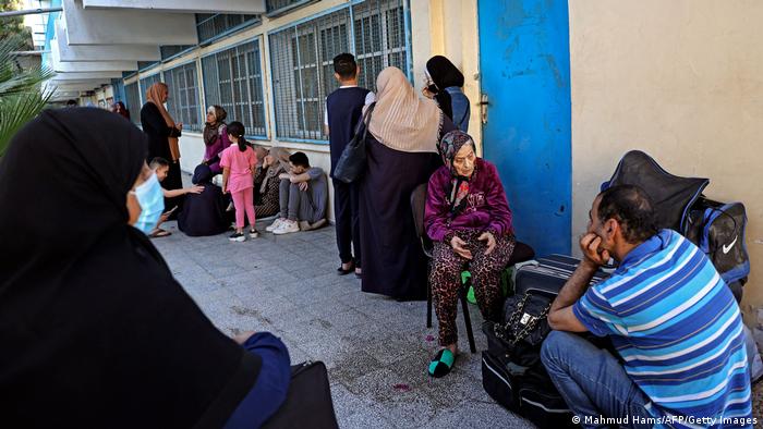 People of all ages sit in front of the UN building in Gaza city