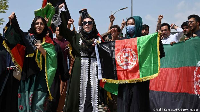 Afghans in Kabul holding up thier national flag in the street