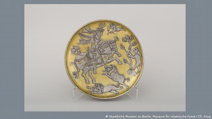 A golden plate decorated with a hunting scene