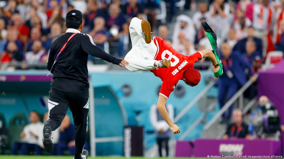Tunisian pitch invader carrying a Palestine flag somersaults during the World Cup match Tunisia vs. France (photo: Matteo Ciambelli/De Fodi Images/picture-alliance)