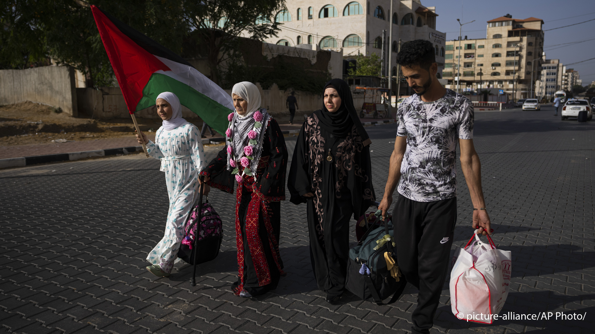 Huda Zaqqout, second left, walks with her relatives as she leaves Gaza City for the Hajj pilgrimage in Mecca, Saudi Arabia, 13 June 2023 (image: AP Photo/Fatima Shbair)