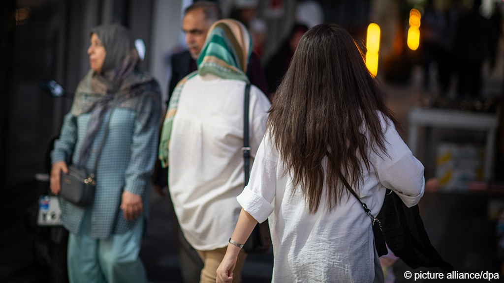 نساء - إحداهن غير مغطاة الشعر - يمشين في أحد شوارع طهران - إيران. Women, one of whom does not have her hair covered, walk along a street in Tehran (photo: Arne Immanuel Bänsch/dpa/picture alliance)