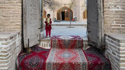 Ein Mädchen wartet an der Türschwelle zum Mausoleum von Sheikh Ahmad e-Dscham in der nordostiranischen Stadt Torbat e-Dscham