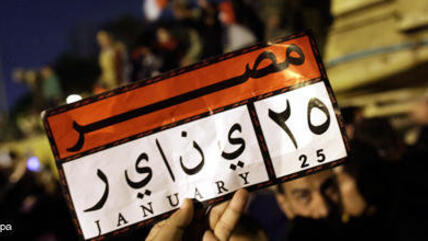 A demonstrator holding a small placard referring to the start of the Egyptian Revolution on 25 January (photo: dpa)