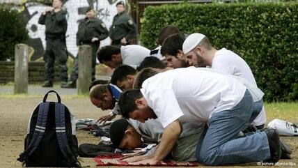 Salafisten beten in einer Fußgängerzone in Deutschland; Foto: dpa/picture-alliance