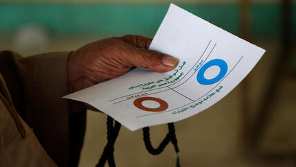 Ägypter hält bei der Stimmabgabe zum Referendum einen Wahlzettel; Foto: dapd