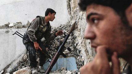 A rebel fighter keeps an eye out for Syrian regime forces as they plan to attack and neutralize a tank positioned on the street ahead in the Karmel al-Jabl district of Aleppo, on October 31, 2012 (photo: Javier Manzano/AFP/Getty Images9