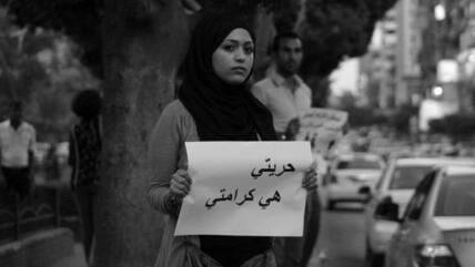 A women demonstrating in Cairo and holding up a sign that reads 'My freedom is my dignity' (photo: AP)