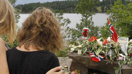 Two young women stand in silence after placing flower near Sundvollen close to the Utoya island, near Oslo, Norway, Tuesday, July 26, 2011 (photo: dapd)