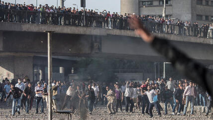 Members of the Black Bloc movement and the Muslim Brotherhood throw stones at each other during clashes in central Cairo, Egypt, 19 April 2013 (photo: picture-alliance/AP)