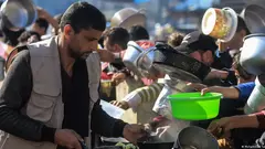 Ein Helfer einer Wohltätigkeitsorganisation im Gazastreifen versorgt Hunderte hungrige Menschen mit einer warmen Mahlzeit.
