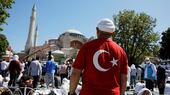 Man stands in front of the Hagia Sophia, his back to the camera, wearing a Turkish flag t-shirt