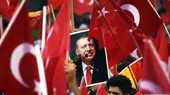 Anhänger des türkischen Präsident Recep Tayyip Erdogan halten türkische Fahnen und sein Bild.