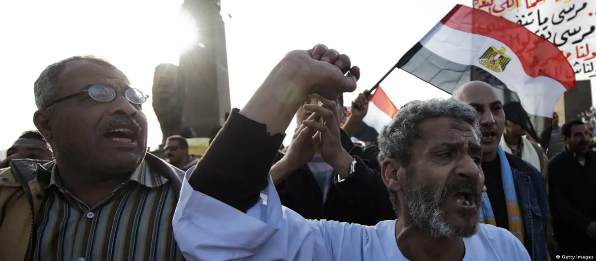Egyptians waving an Egyptian flag demonstrate against the Muslim Brother Mohammed Morsi