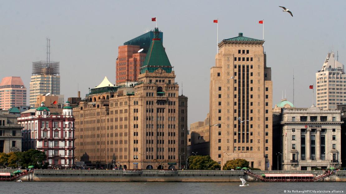 ما يُعرف اليوم بفندق السلام كان حتى عام 1949 يسمى فندق كاثي بُني عام 1929 على يد تاجر يهودي بمدينة شنغهاي - الصين. ‏(Foto: Xu Ruikang/HPIC/dpa/picture-alliance) Peace Hotel (l.) mit grünem Pyramidendach in Shanghai