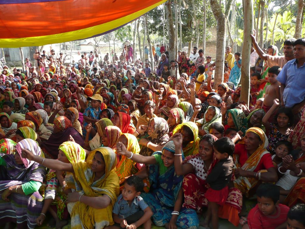 Large group of women in Bangladeshi attire gathered together outside