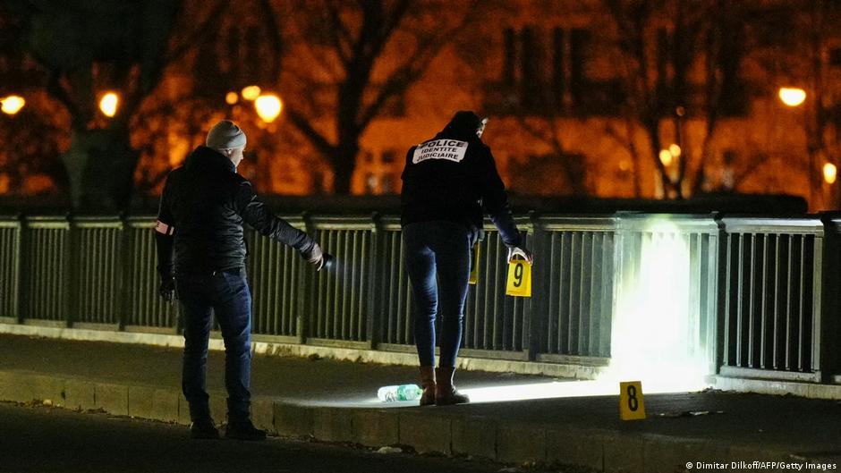 Forensic police continue to work as night falls at the scene of a stabbing in Paris 