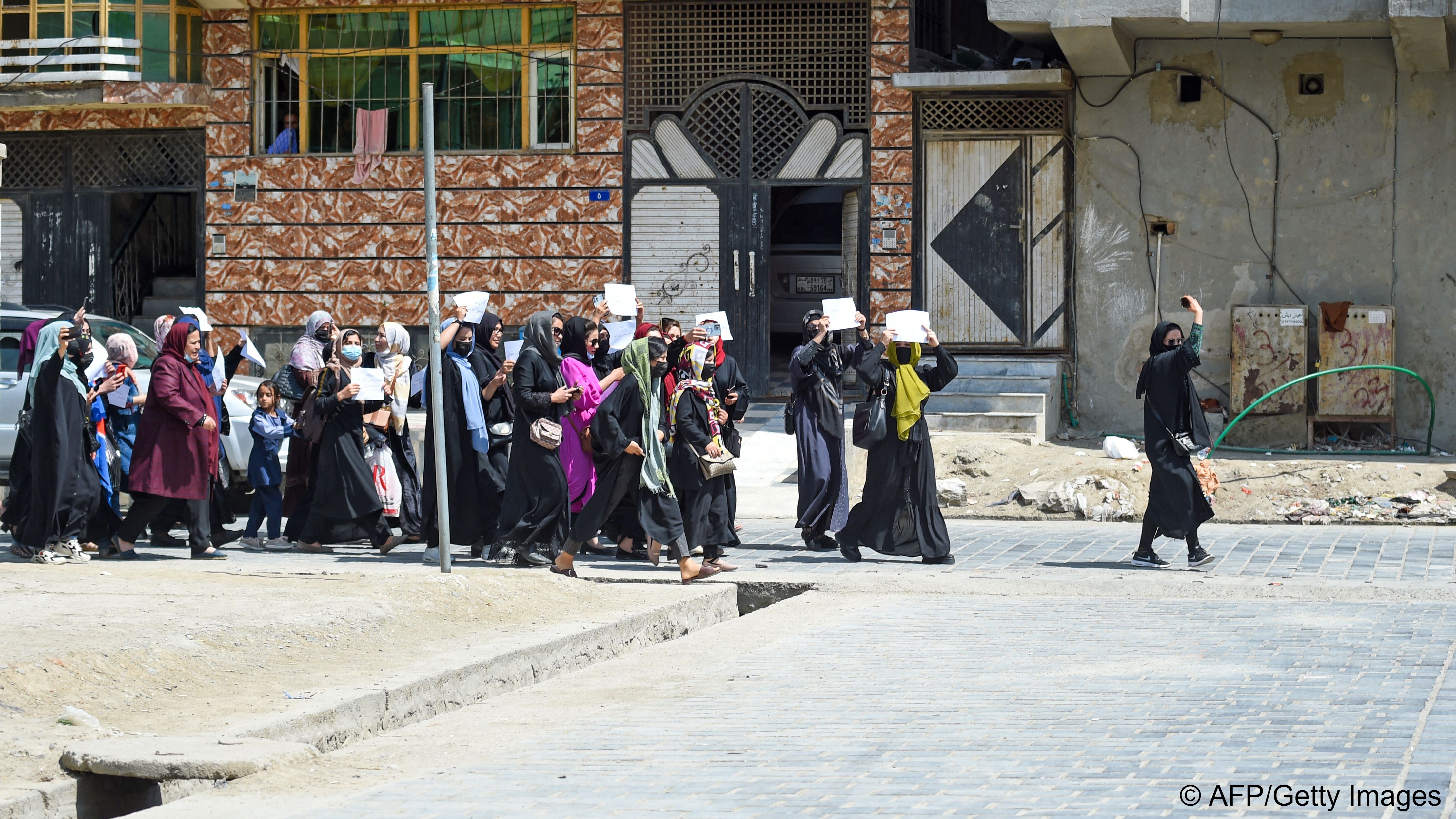 A group of women holding up placards walks along a street as they protest for their rights, Kabul, Afghanistan, 29 April 2023