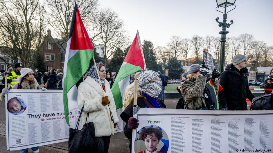 A protestor holds a Palestinian flag during a demonstration simultaneously at the hearing at the International Court of Justice (ICJ) on a genocide complaint by South Africa against Israel, in The Hague