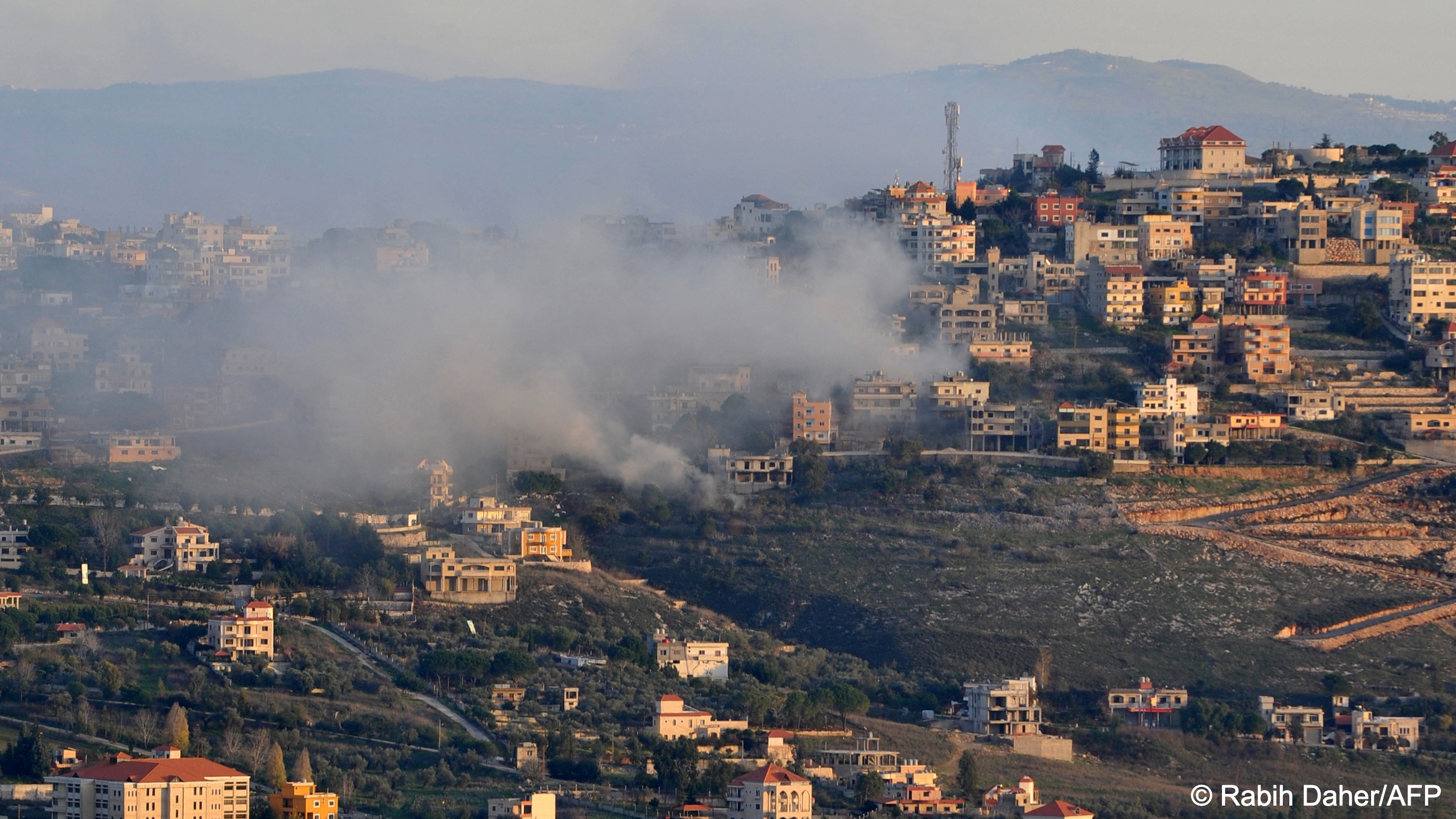 Smoke from Israeli bombs drifts across a settlement on a hill in Lebanon
