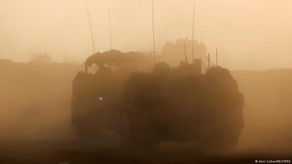 Israeli military vehicles manoeuvre along the border fence on the Israeli side of the border with Central Gaza