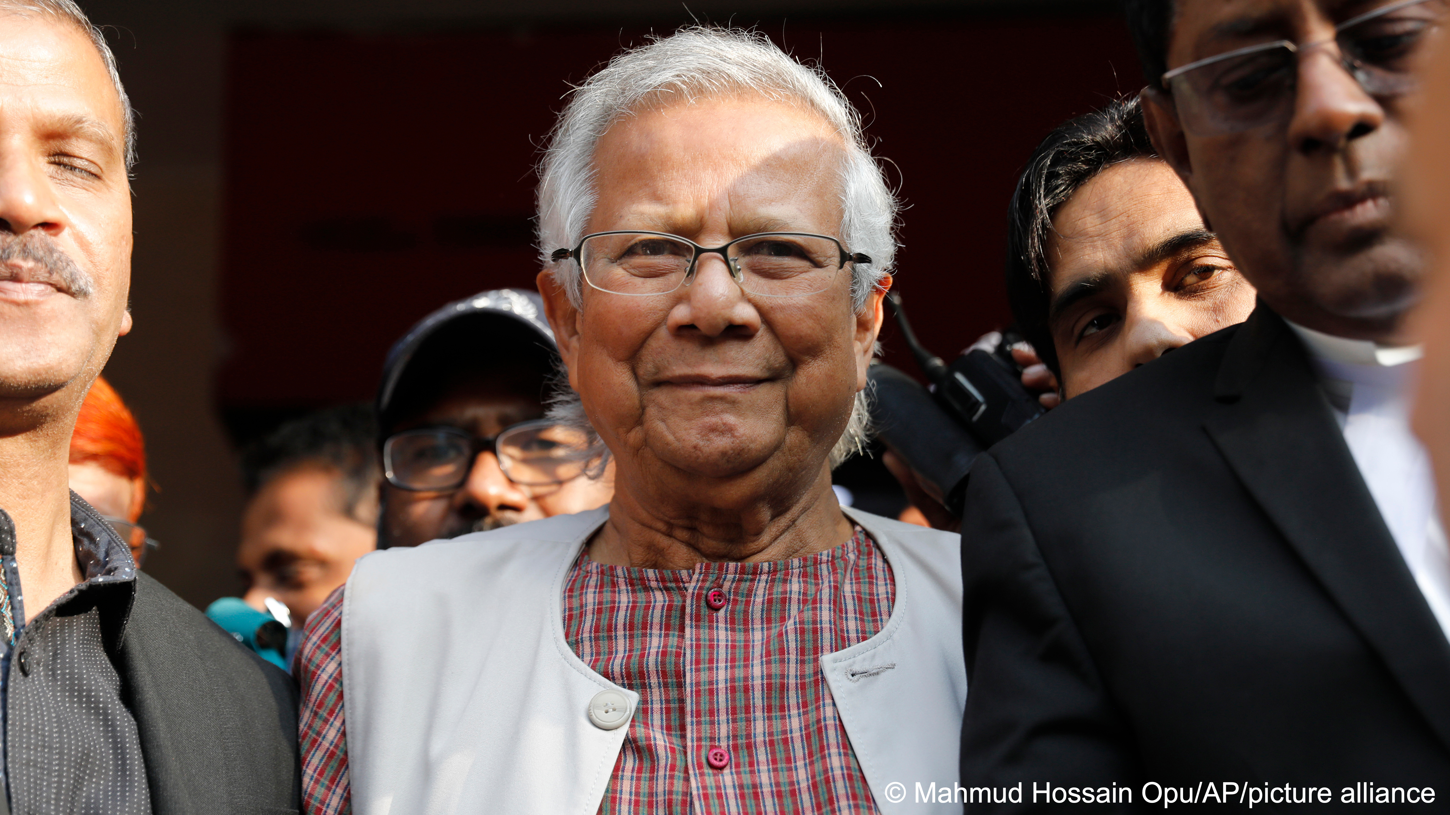 Nobel Peace Prize winner Muhammad Yunus is surrounded by people as he leaves court after being sentenced to six months in jail for labour law violations in Dhaka, Bangladesh, 1 January 2024 