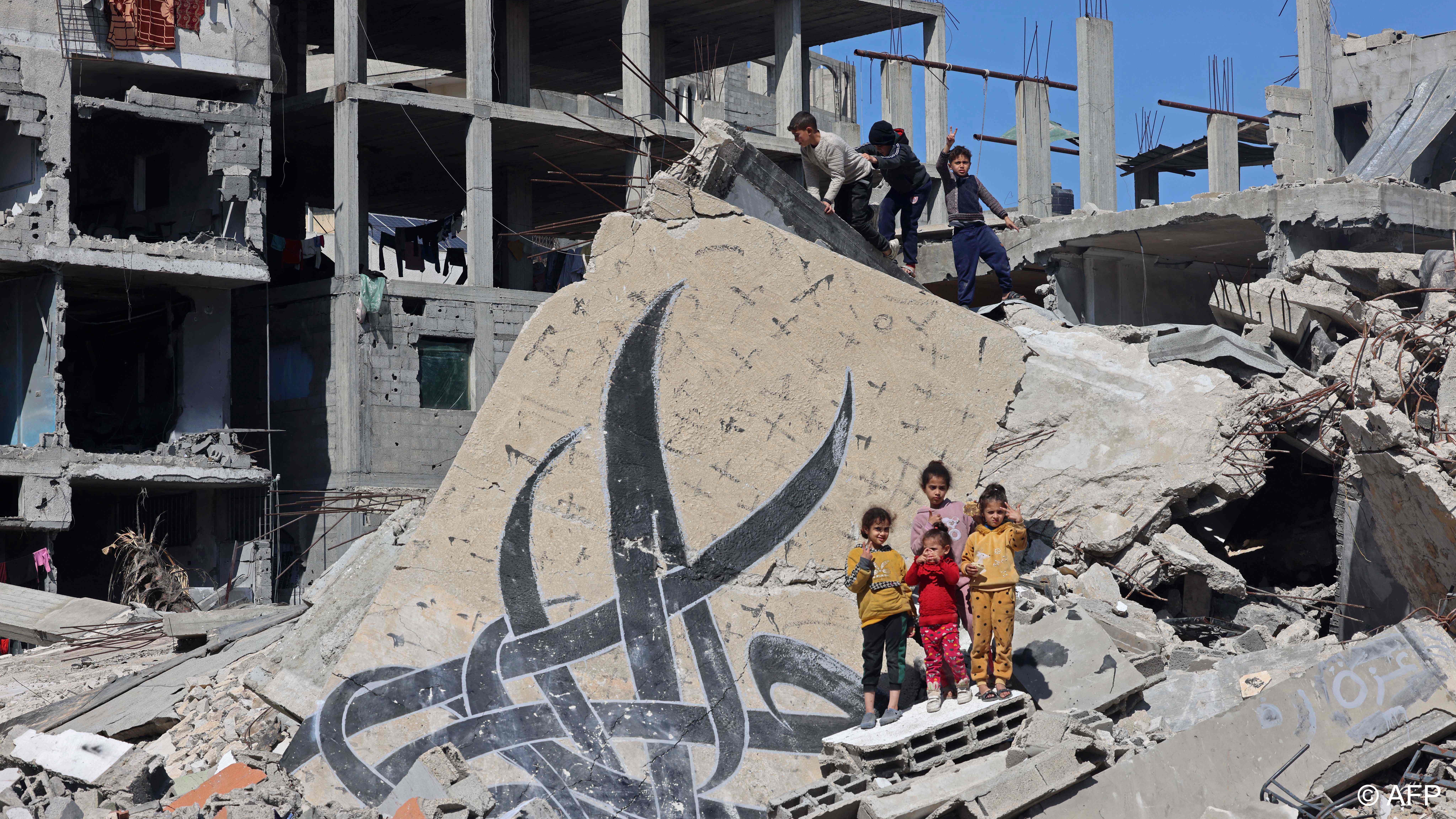 Palestinian children clamber on the ruins of buildings in Gaza following recent Israeli strikes