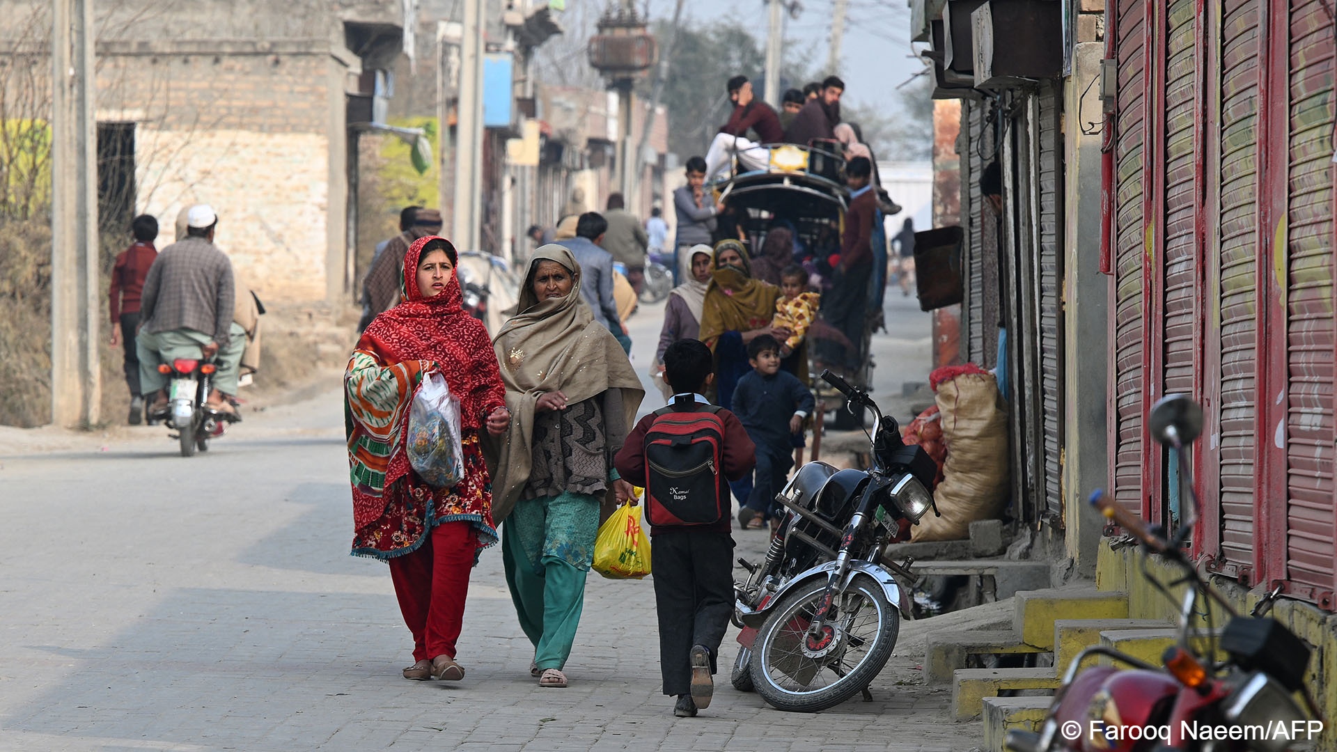 Pakistani women walk down a street in Dhurnal, Punjab