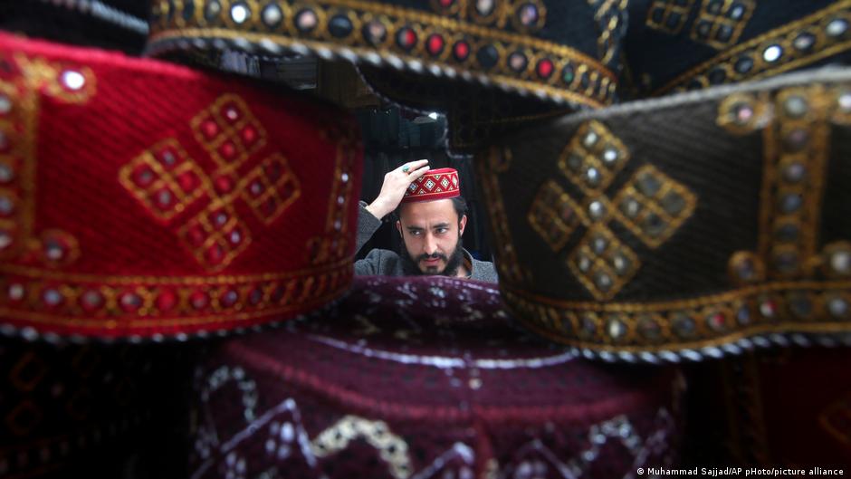 Ein junger Pakistani in Peschawar probiert den Sitz der traditionellen Kopfbedeckung