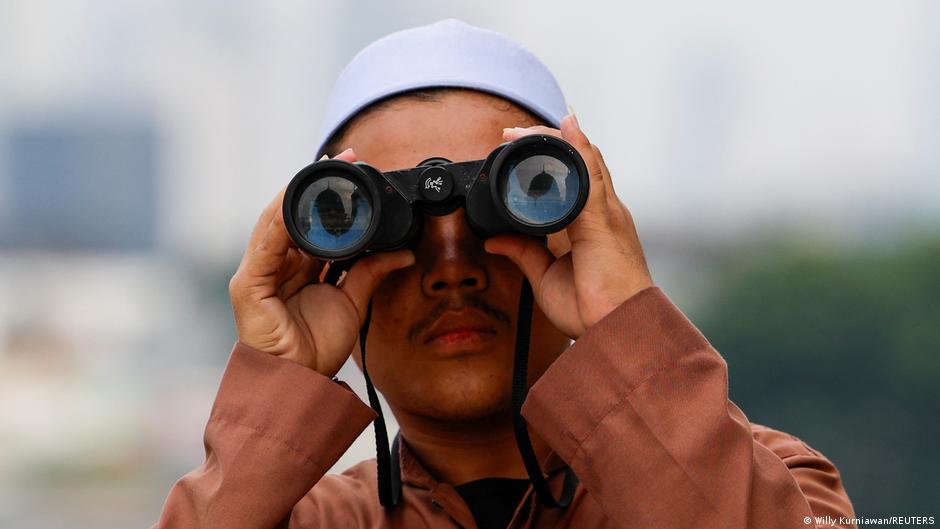 A Muslim in Jakarta watches the position of the crescent moon over Indonesia from the roof of the Al-Musyari'in mosque