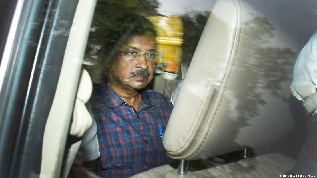 Arvind Kejriwal looks serious as he is seen through the window of a car being driven to court in Delhi, India, 28 March 2024